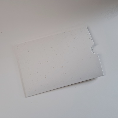 Envelope branco com partículas naturais visíveis