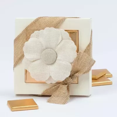 Caixa de presente branca com fita de juta e flor de tecido com chocolates dourados à volta