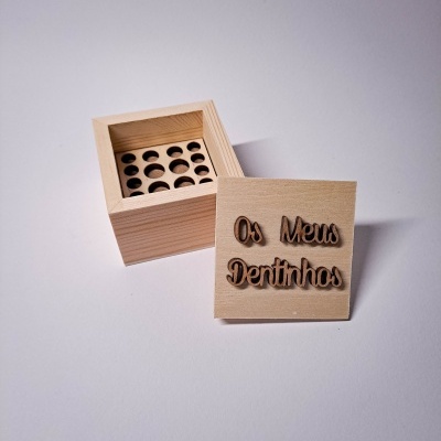 Caixa de madeira clara com tampa com texto 'Os Meus Dentinhos'
