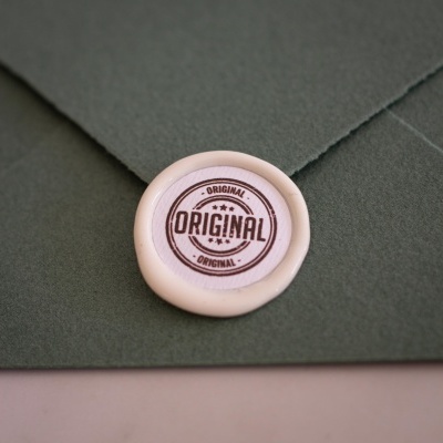 Envelope verde com selo branco redondo com texto ORIGINAL