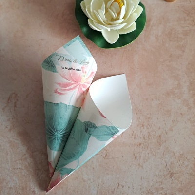 Dois cones de papel floral com texto e flor artificial branca no fundo