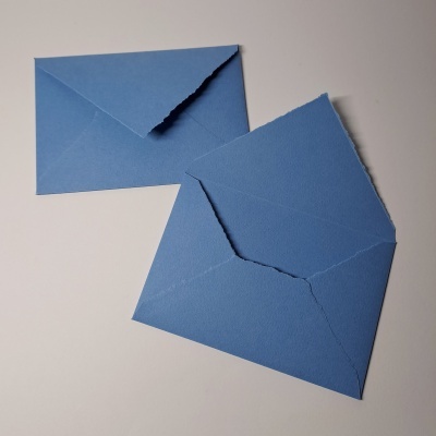 Dois envelopes azuis em papel texturizado sobre fundo branco