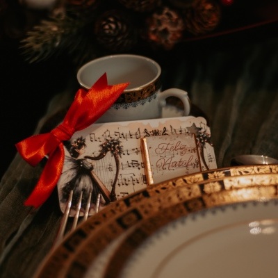 Conjunto de jantar com padrão dourado, chávena, garfo e cartão de Natal com laço vermelho