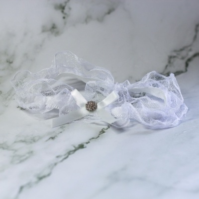 Liga branca de renda com fita de cetim e ornamento brilhante