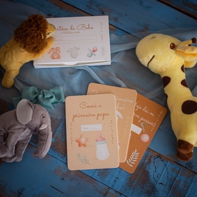 Cartões de bebé em tons cor de pêssego com peluches animal sobre fundo azul