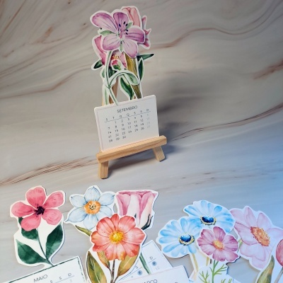 Calendário de mesa com flores em aquarela e suporte de madeira.