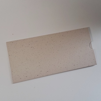 Envelope retangular bege com manchas pretas sobre fundo branco