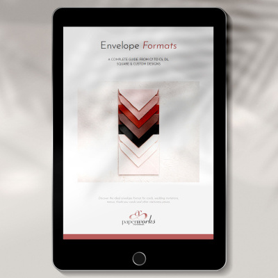 Tablet preto com guia de formatos de envelopes em tons de rosa, vermelho e preto.