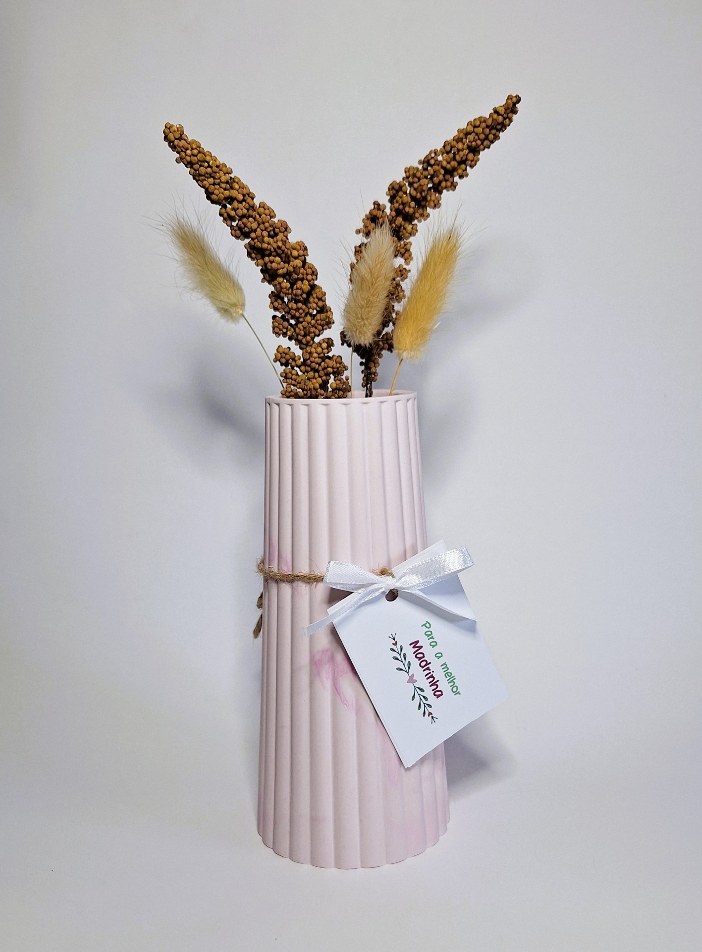 Jesmonite: O Que É e Por Que Está a Conquistar o Mundo do Artesanato? Vaso rosa com flores secas e etiqueta branca pendurada