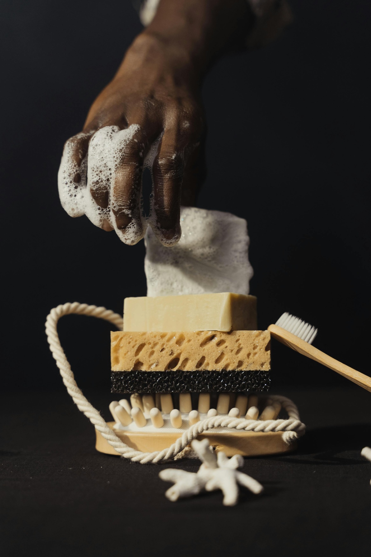 Como Ler os Rótulos de Produtos Naturais: O Guia Completo Mão com espuma segura toalhete em esponja junto a escova de dentes e corda enrolada