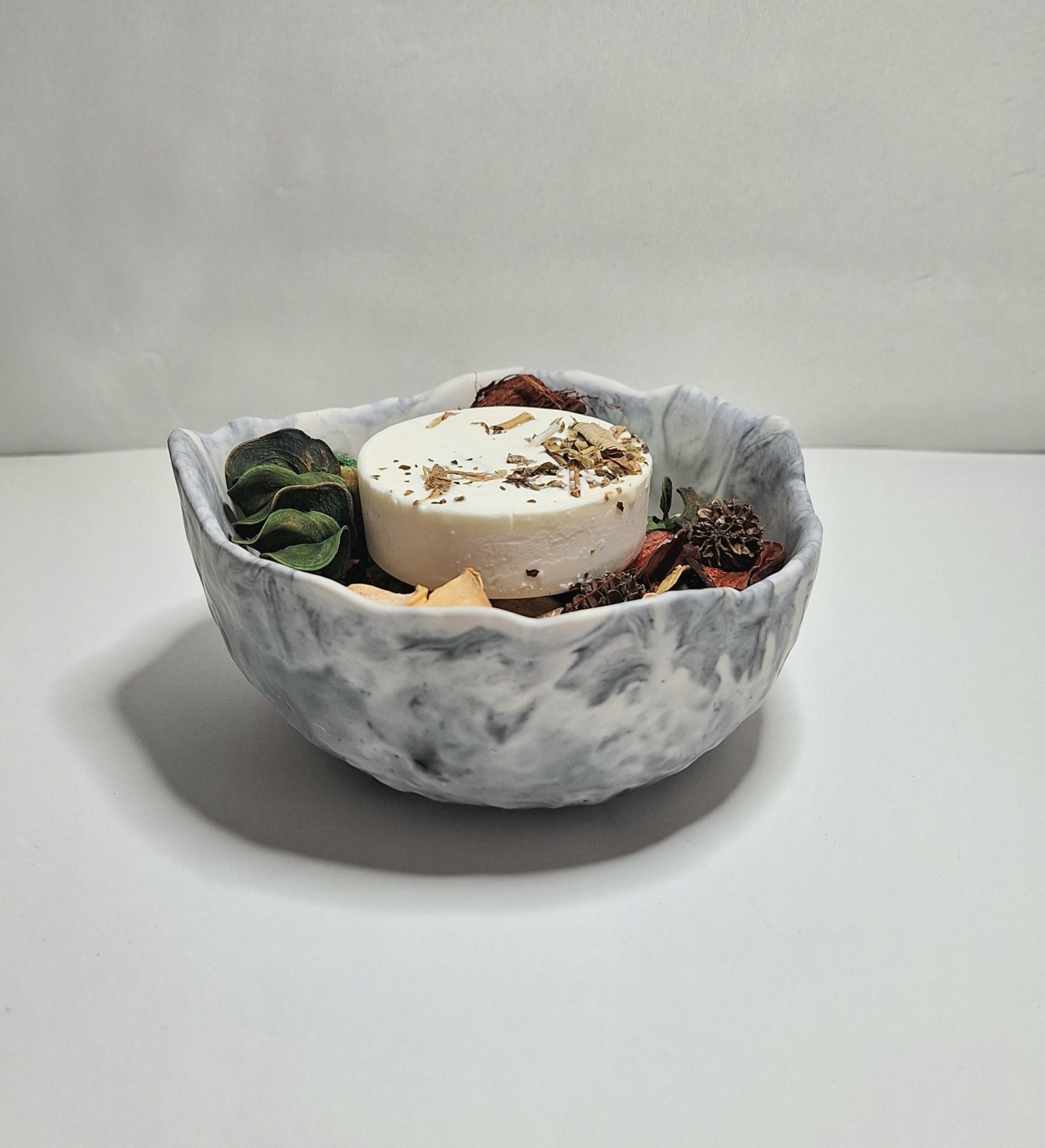 Cuidados e Manutenção: Como Garantir a Durabilidade das Peças em Jesmonite Recipiente cinza com sabonete branco e folhas secas