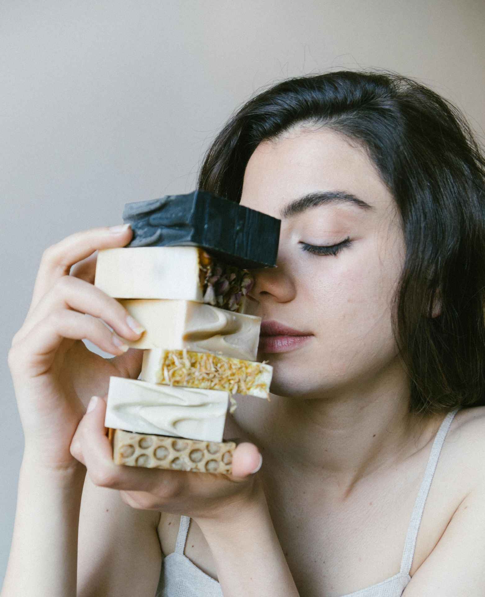 Cremes Hidratantes para o Corpo: Serão os melhores? Mulher segurando barras de sabão artesanais coloridas