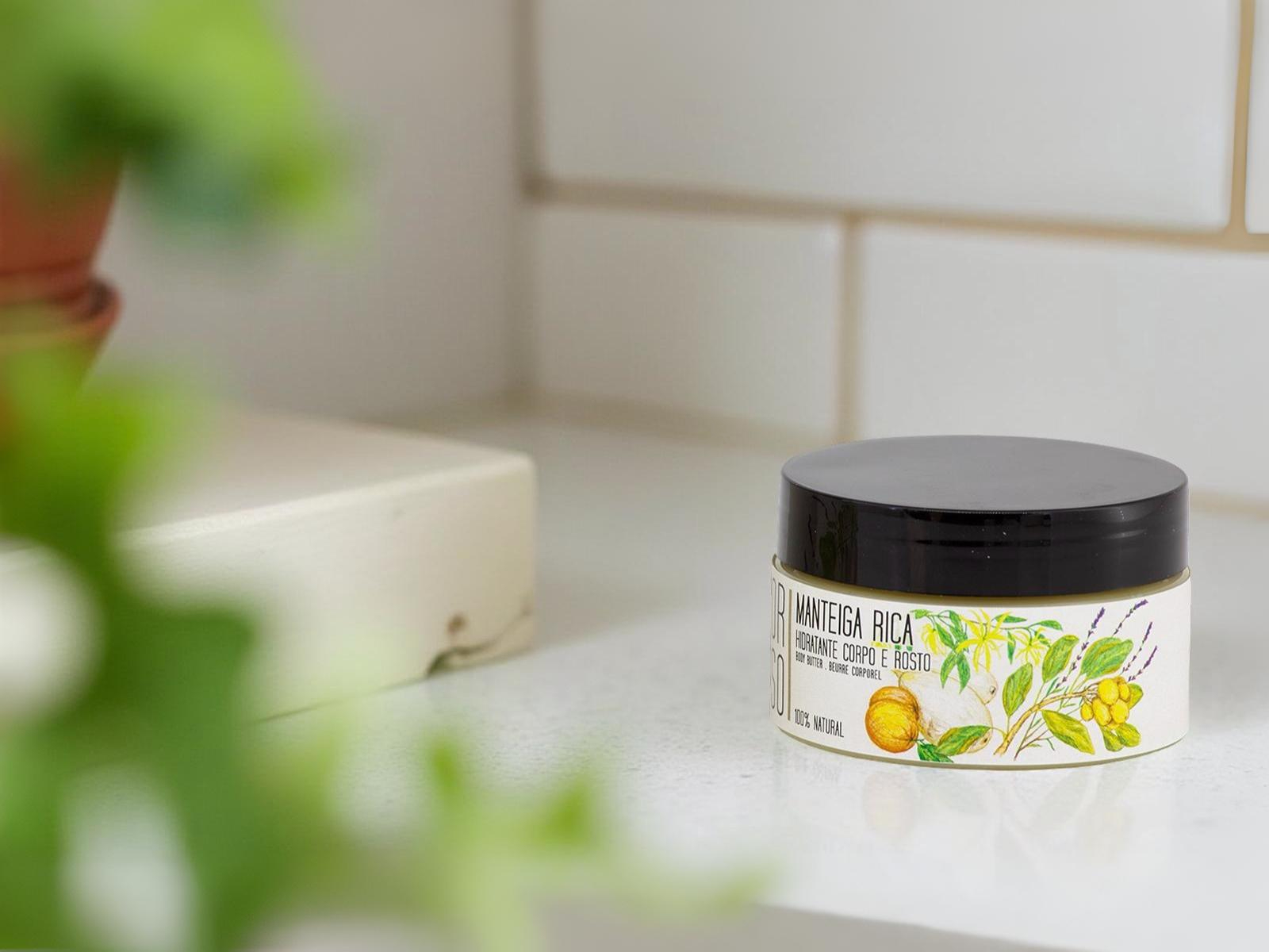 Manteiga Rica com base de manteiga de Karité e Baobá Frasco redondo de creme cosmético com tampa preta em bancada branca