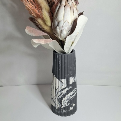 Vaso marmoreado com flores secas em fundo branco