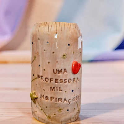 Cilindro decorativo em cerâmica com frase para professora e motivos decorativos coloridos.
