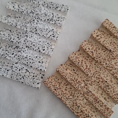 Mosaicos retangulares com texturas pontilhadas em diferentes cores sobre superfície branca