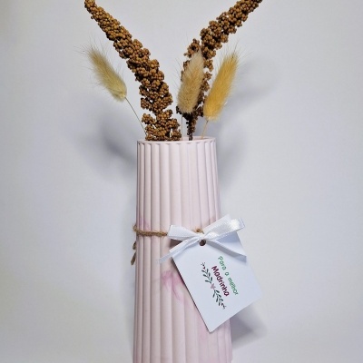 Vaso rosa com flores secas e etiqueta branca pendurada