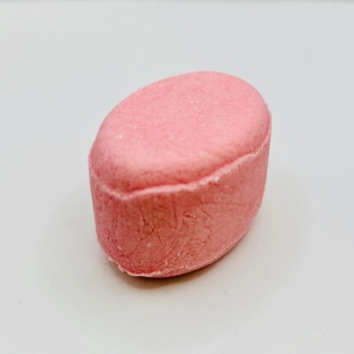 Pastilha rosa sólida ovalada sobre fundo branco