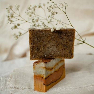 Dois sabonetes empilhados com flores brancas ao fundo