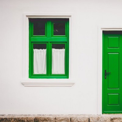 Parede branca com janela verde e porta verde