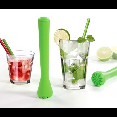 Dois copos de bebidas e utensílios verdes para esmagar, com limas ao fundo