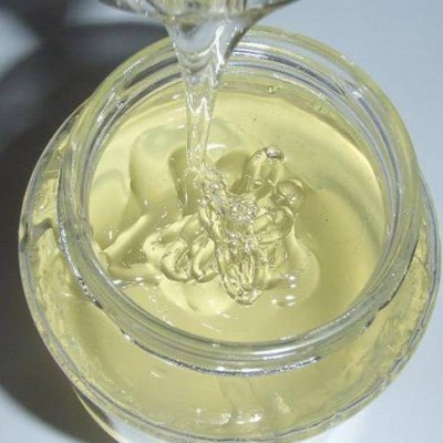 Frasco de vidro com líquido viscoso transparente a ser vertido