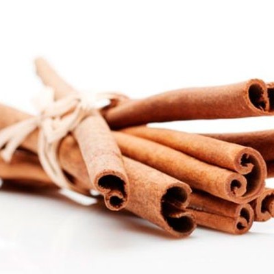 Paus de canela amarrados num feixe sobre fundo branco