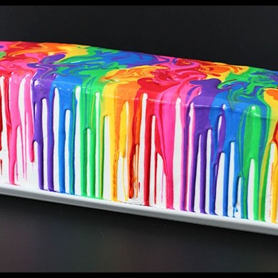 Bolo retangular com glacê colorido em arco-íris num prato branco