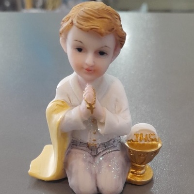Figura de criança ajoelhada com roupa branca e amarela e cálice dourado