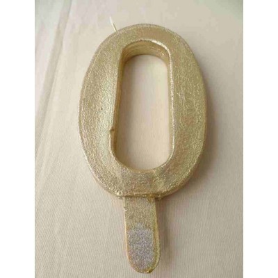 Vela dourada em forma de número 0 com suporte