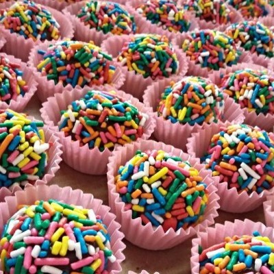 Brigadeiros com granulados coloridos em forminhas de papel rosa