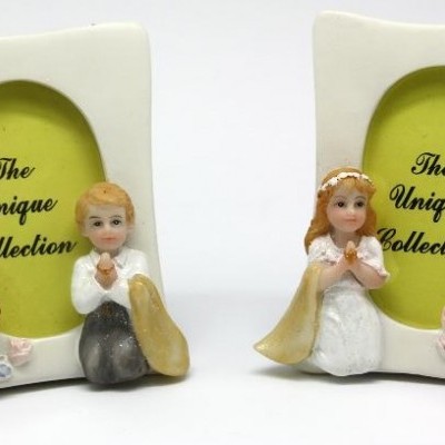 Dois porta-retratos cerâmicos com figuras de crianças ajoelhadas, texto The Unique Collection no centro em fundo verde