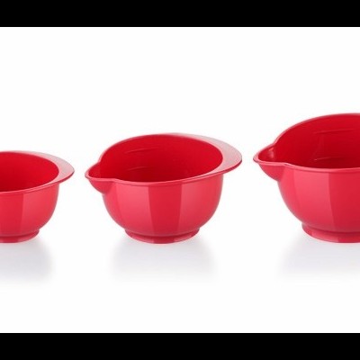Três taças vermelhas de plástico com bico, em três tamanhos diferentes, sobre fundo branco