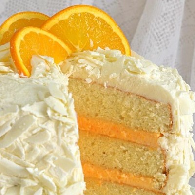 Bolo decorado com raspas de chocolate branco e fatias de laranja