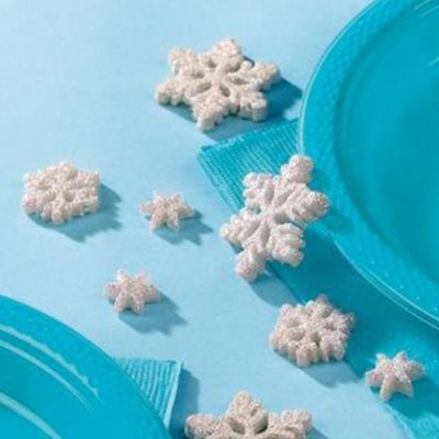 Pratos e guardanapos azuis com flocos de neve brancos decorativos