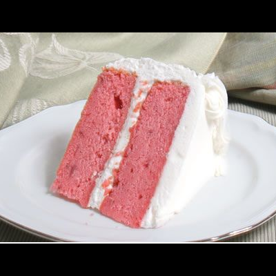 Fatia de bolo cor-de-rosa com cobertura branca num prato branco com borda prateada