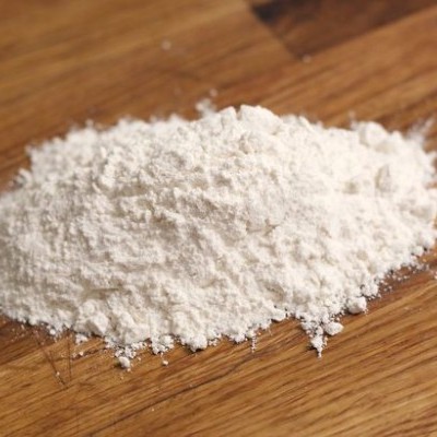 Montinho de farinha branca sobre madeira