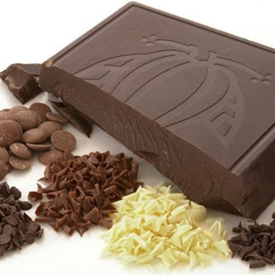 Barra de chocolate escuro com gravação e várias raspas de chocolate em tons diferentes