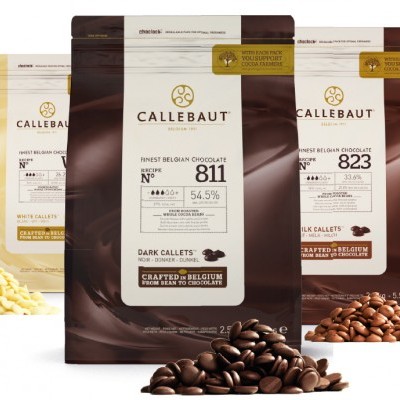 Três embalagens de chocolate Callebaut com amêndoas de chocolate à frente.