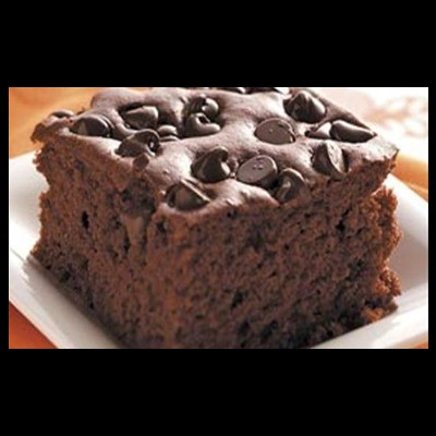 Quadrado de bolo de chocolate com pedaços de chocolate no topo