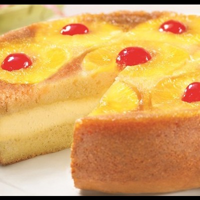 Bolo redondo com fatias de ananás e cerejas