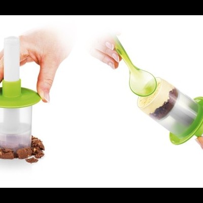 Utensílio de cozinha plástico verde e transparente para moldar bolos pequenos.