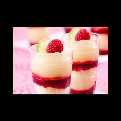 Dois copos de vidro com doce em camadas decorado com framboesa e lima