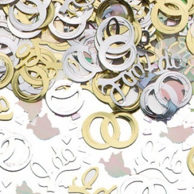 Confetes metalizados dourados e prateados com formas de anéis e palavras sobre mesa.