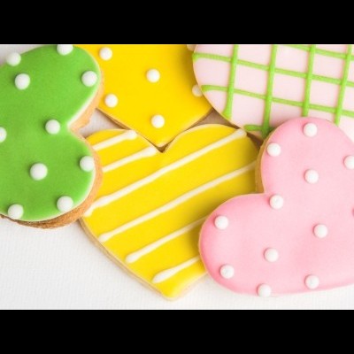 Bolachas em forma de coração decoradas com glacê colorido sobre fundo branco