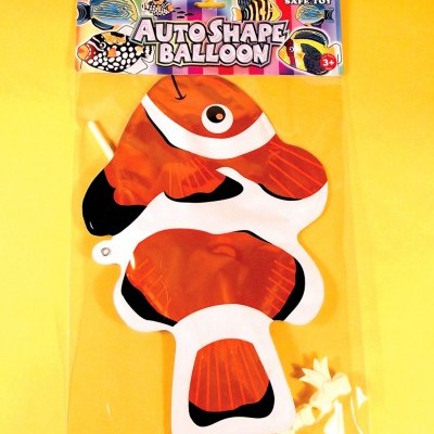 Balão em forma de peixe palhaço em embalagem plástica transparente sobre fundo amarelo