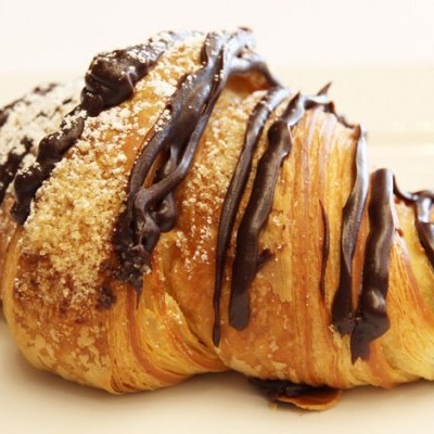 Croissant com chocolate e granulados em prato branco