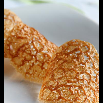 Peças de tuille crocante dourada em prato branco