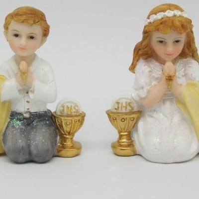 Figuras decorativas de menino e menina ajoelhados com cálices dourados e inscrições JHS 2017