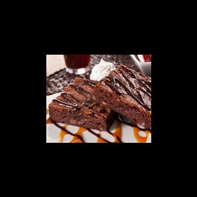 Bolo fudge de chocolate com cobertura e calda sobre um prato branco